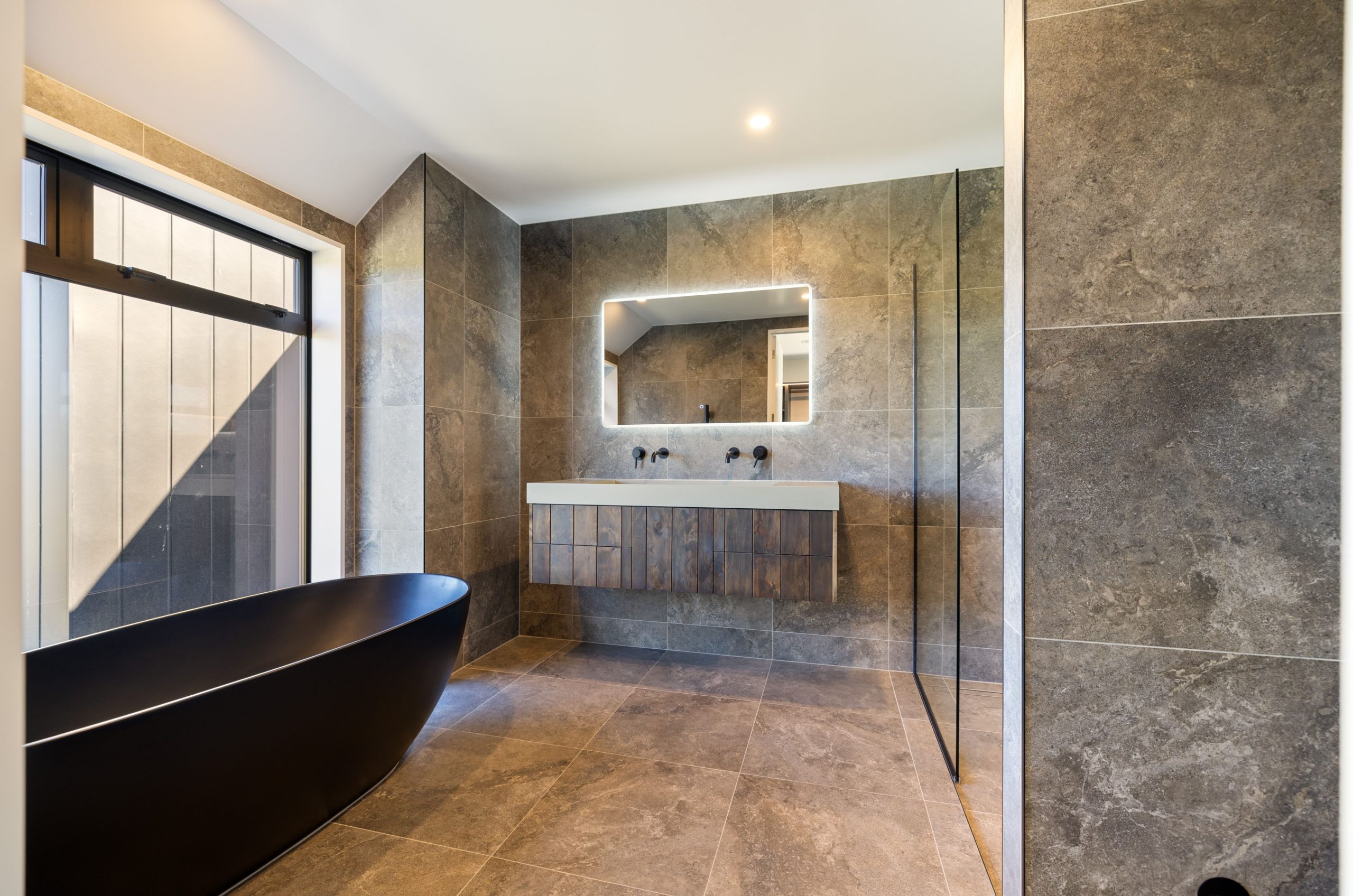 Luxury ensuite with freestanding tub, double vanity, and matte black tapware