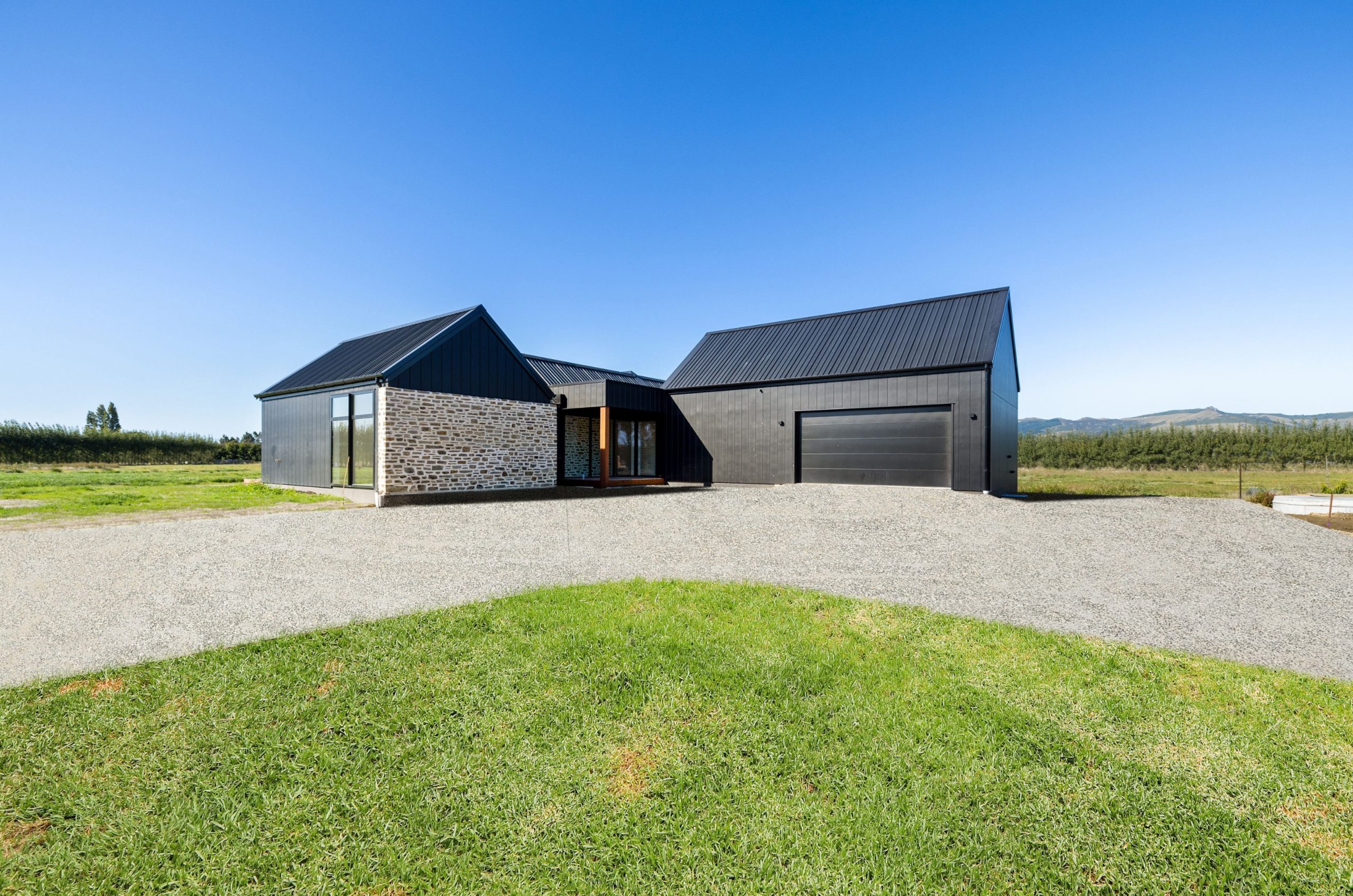 Striking modern farmhouse with black and cedar exterior in West Melton