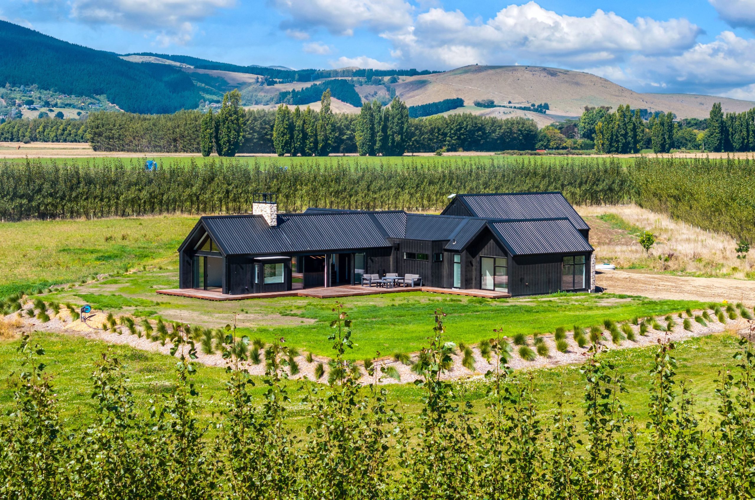 Striking modern farmhouse with black and cedar exterior in West Melton
