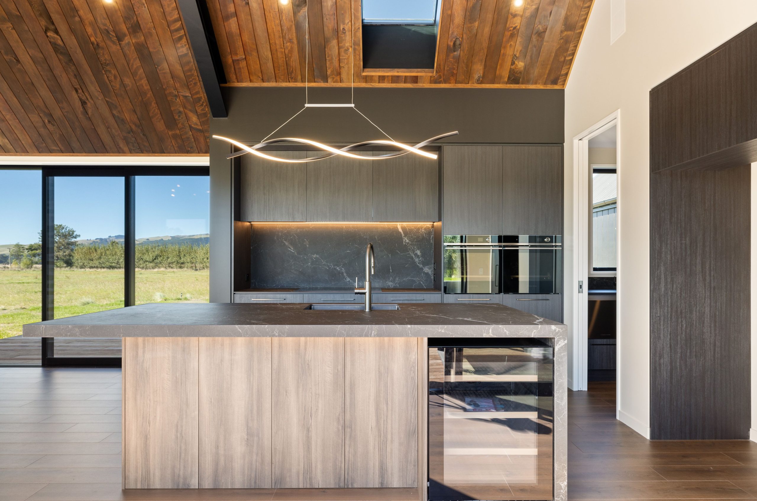 Large open-plan kitchen with butler’s pantry, stone benchtops and pendant lights