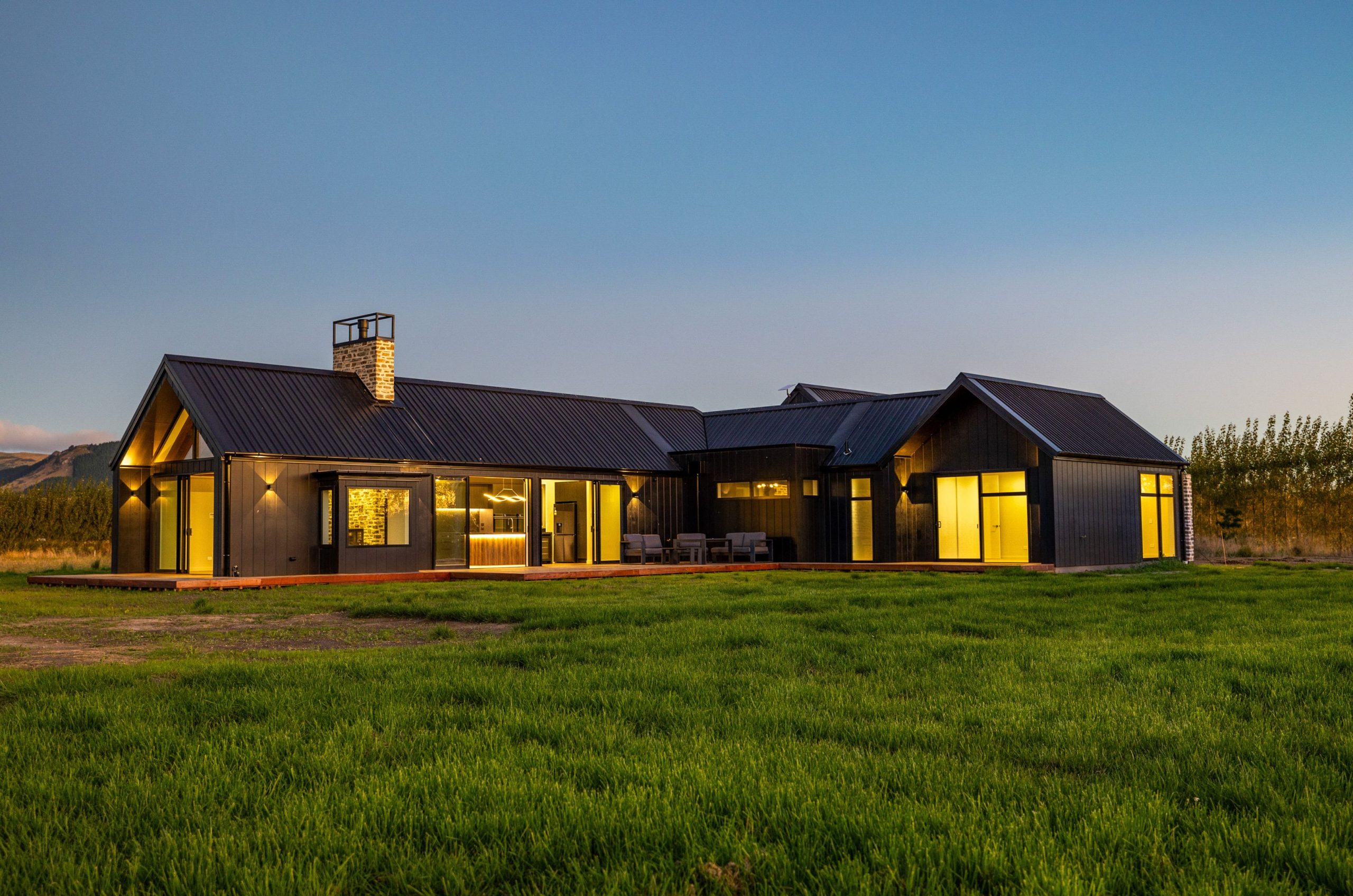 Sunset view of the West Melton home highlighting the architectural design