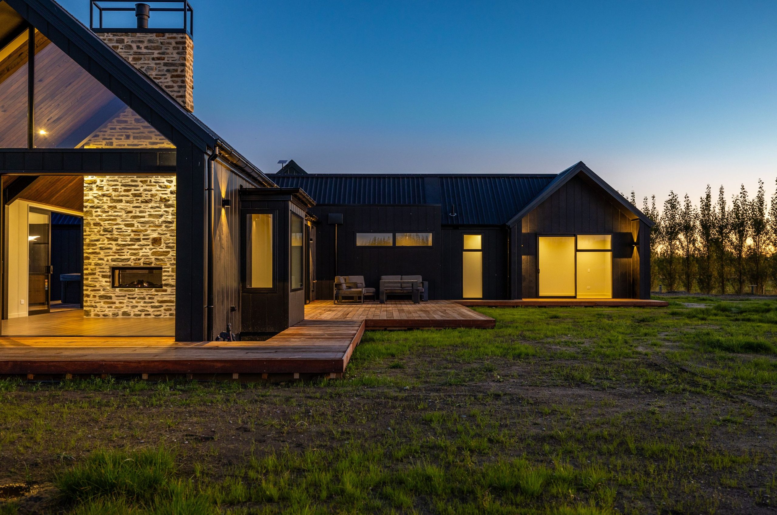 Sunset view of the West Melton home highlighting the architectural design